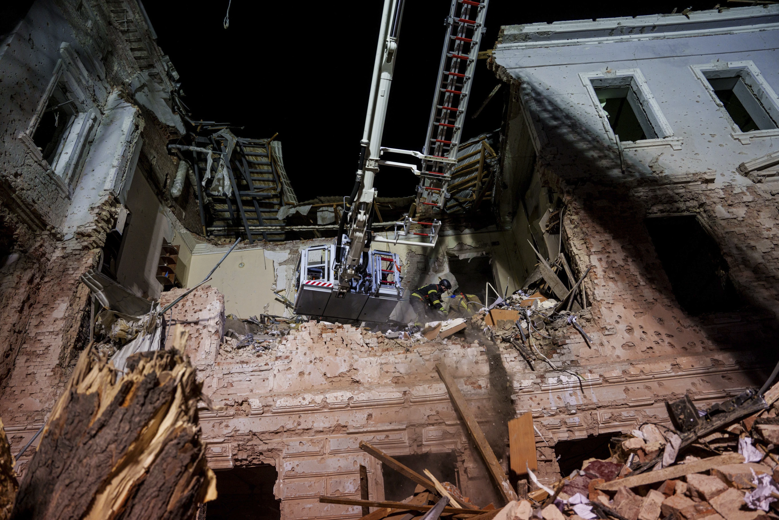 Рятувальники розчищають завали будівлі університету, зруйнованого російським ракетним ударом по Сумах, Україна, неділя, 13 квітня 2025 р.